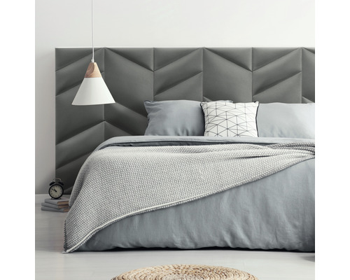 Šedá ložnice s čalouněným čelem a lampičkou