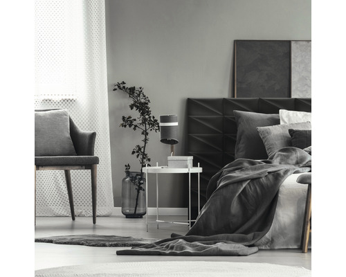 Ložnice s postelí, nočním stolkem, lampou a židlí.