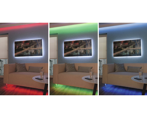 Obývací pokoj s osvětleným obrazem na stěně a nepřímým osvětlením v různých barvách