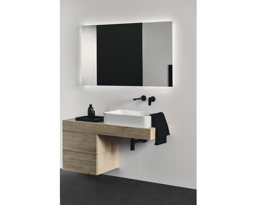 Moderní koupelna s umyvadlovou skříňkou, umyvadlem na desku a osvětleným zrcadlem