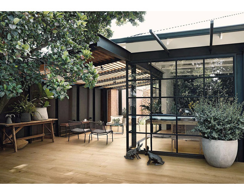 Venkovní prostor s dřevěnou podlahou, posezením a rostlinami