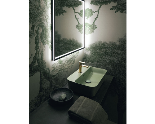 Koupelna s osvětleným zrcadlem, umyvadlem, baterií, miskou na mýdlo a ručníkem