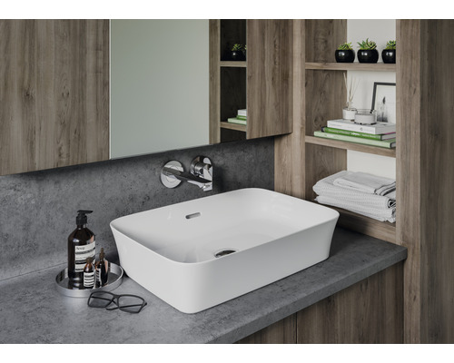 Moderní koupelna s umyvadlem na desku, baterií, zrcadlem a dřevěnými policemi.