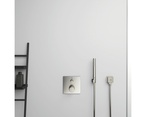 Nástěnná sprchová armatura s ruční sprchou a úložnou policí v koupelně