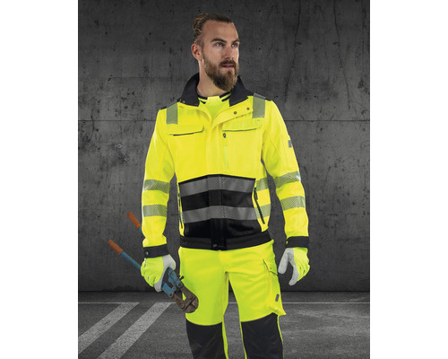 Muž má na sobě žlutou výstražnou bundu a kalhoty s nůžkami na tyče