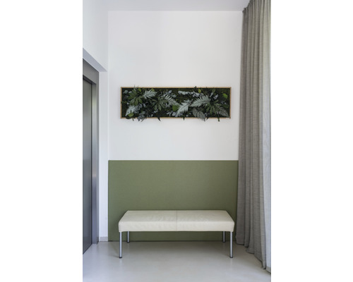 Nástěnná dekorace s umělými rostlinami nad lavicí ve světlé místnosti