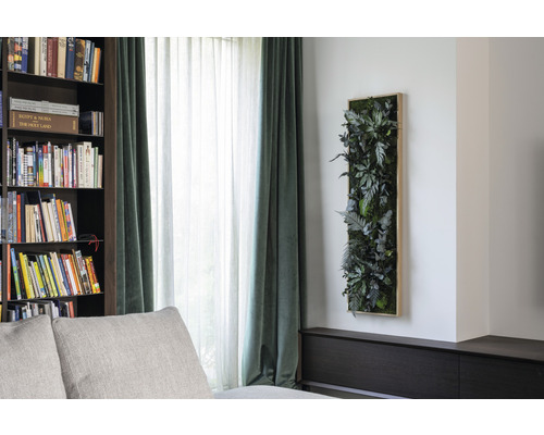 Dekorativní nástěnný panel s umělými rostlinami v obývacím pokoji.