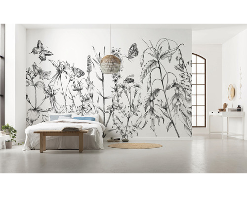 Prostorná ložnice s květinovou fototapetou, postelí a proutěnou lampou