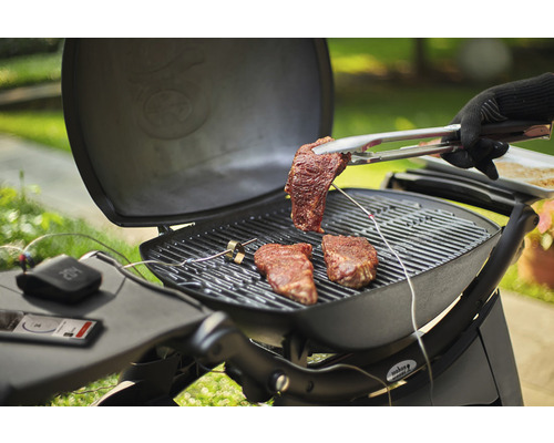 Scéna grilování se steaky na grilu a grilovacími kleštěmi se steakem