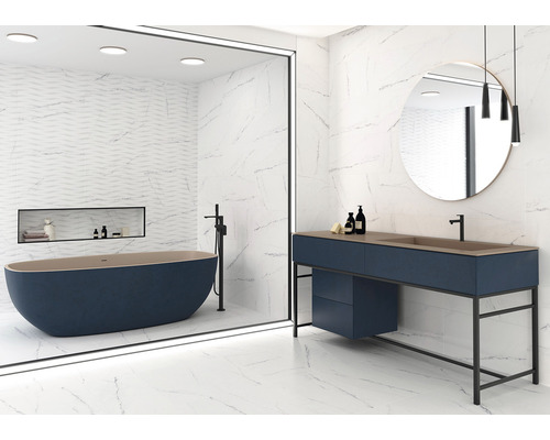 Světlá koupelna s volně stojící vanou, umyvadlem a velkoformátovými dlaždicemi se vzhledem mramoru