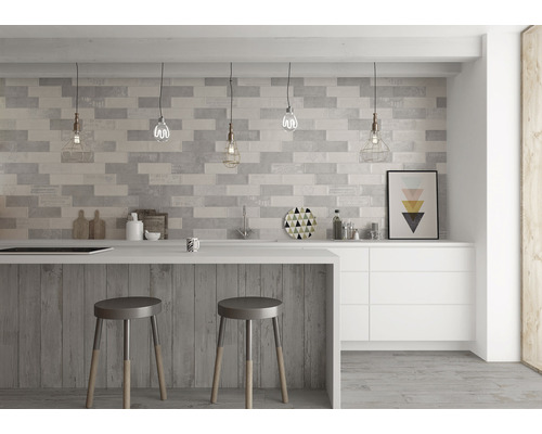Moderní kuchyně s obkládanou stěnou, kuchyňským ostrůvkem a barovými stoličkami.