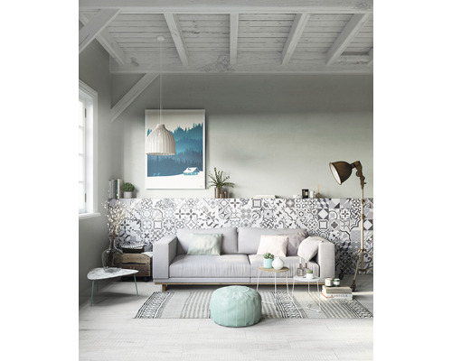 Světlý obývací pokoj s pohovkou, vzorovanými dlaždicemi a dekoracemi pro útulnou atmosféru