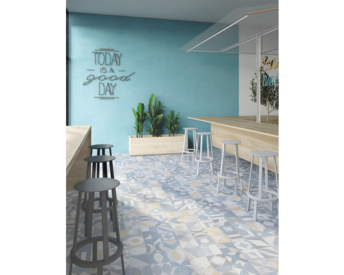 Interiér s barovými stoličkami, pultem a podlahovými dlaždicemi s různými vzory