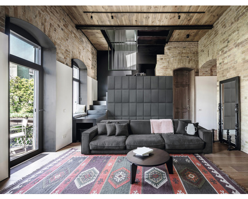 Obývací pokoj s pohovkou, kobercem a cihlovou zdí