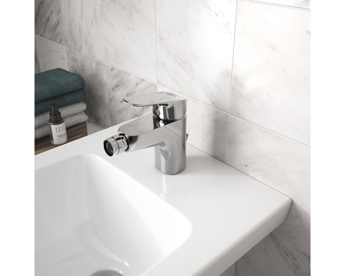 Bidetová baterie na bílém umyvadle v koupelně