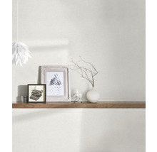 Obývací pokoj s tapetou, policí a dekorativními prvky, jako jsou rámečky a váza