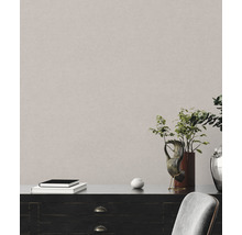 Detailní záběr strukturované nástěnné tapety v interiéru s komodou a dekorací.