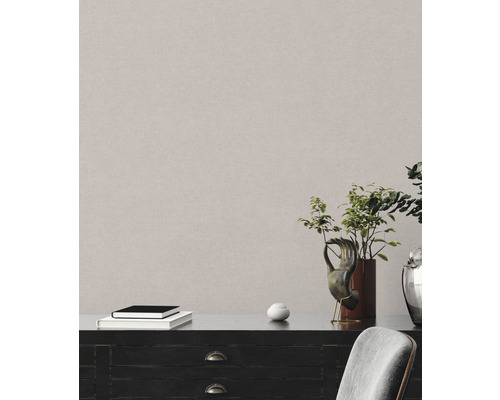 Detailní záběr strukturované nástěnné tapety v interiéru s komodou a dekorací.