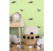 Dětský pokoj s tapetou s koňmi, nočním stolkem, hračkami a košem s medvědem.