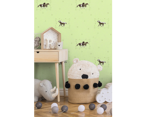 Dětský pokoj s tapetou s koňmi, nočním stolkem, hračkami a košem s medvědem.