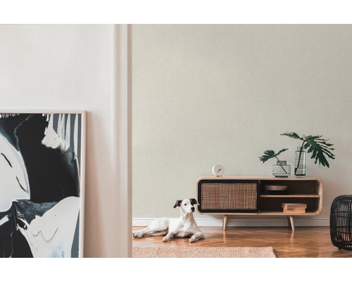 Světlá místnost s tapetou se vzorem, dřevěnou komodou a psem