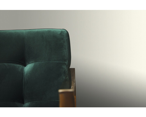 Detail zelené pohovky s prošívaným opěradlem.