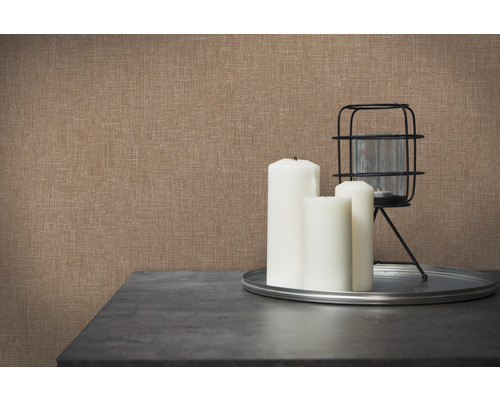 Detail hnědé textilní tapety se svíčkami a dekorací