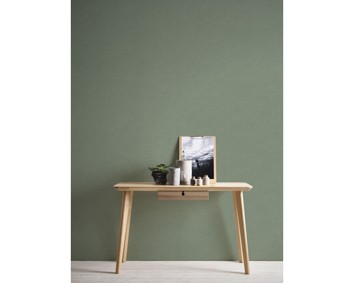 Dřevěný stůl s dekorací před zelenou stěnou