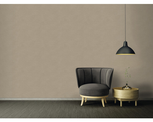 Interiér s křeslem, odkládacím stolkem a závěsnou lampou před béžovou stěnou