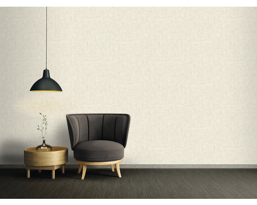 Obývací pokoj s křeslem, odkládacím stolkem a závěsnou lampou před strukturovanou stěnou