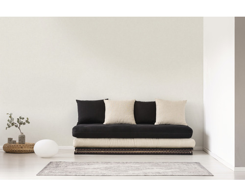 Světlá místnost s futonem, polštáři a dekorací