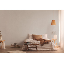 Světlá ložnice s postelí, nočním stolkem, lampou a textilní tapetou