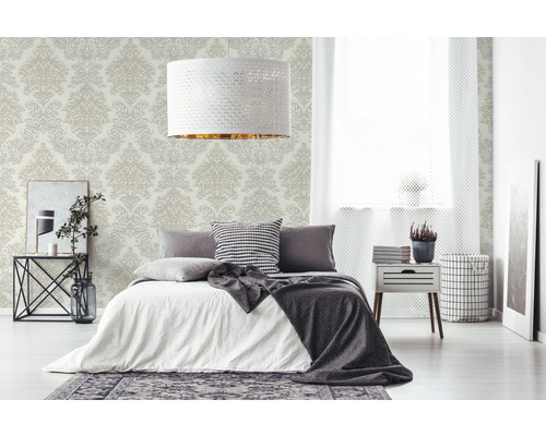 Ložnice s postelí, nočním stolkem a vzorovanou tapetou