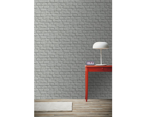 Scéna s cihlovou zdí, stolní lampou, stolem a kobercem