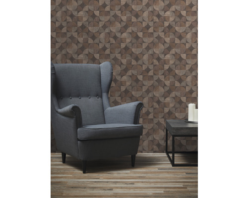 Obývací pokoj s křeslem, odkládacím stolkem a tapetou s geometrickým vzorem