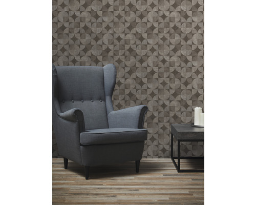 Obývací pokoj s křeslem, stolem a geometrickou tapetou