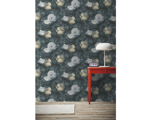 Místnost s květinovou tapetou, červeným stolem a lampou