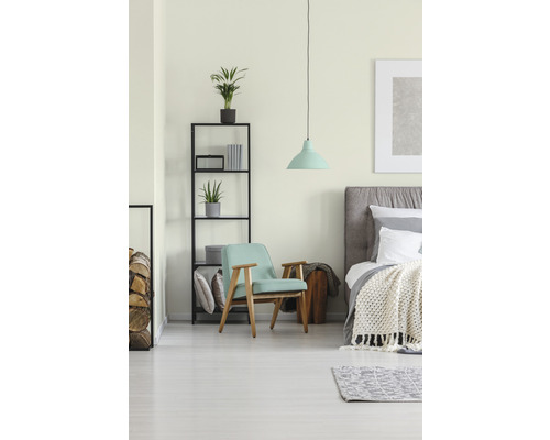 Světlá ložnice s postelí, křeslem, regálem a závěsným svítidlem