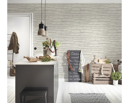 Světlá kuchyně s tapetou imitující zdivo, kuchyňským ostrůvkem, závěsnými lampami a dekoracemi