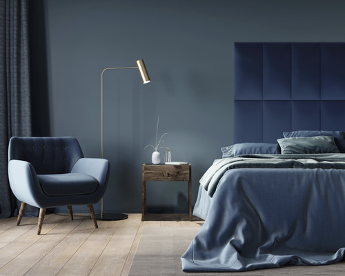 Ložnice s postelí, křeslem, stojací lampou a nočním stolkem