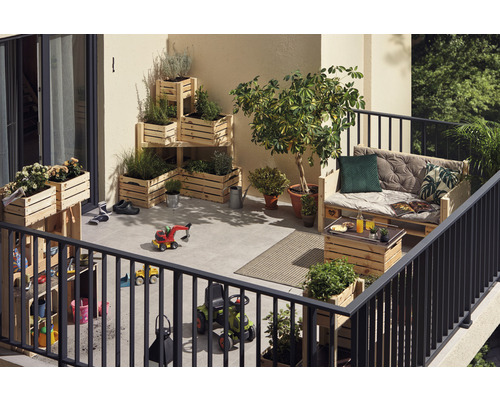 Balkon s rostlinami v dřevěných bednách, dřevěná paleta jako sedátko a dětské hračky