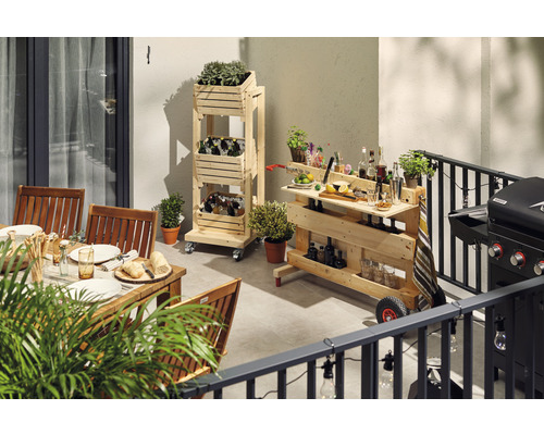 Venkovní scéna s dřevěným nábytkem, včetně stolu se židlemi, regálového vozíku a servírovacího vozíku s grilem