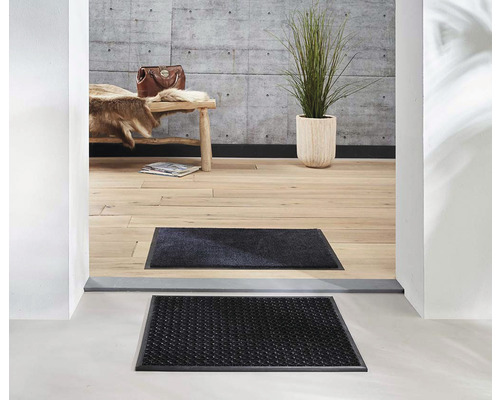 Scéna s rohožkami před vchodem do domu.