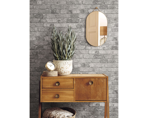 Šedá tapeta s cihlovým vzorem s komodou, zrcadlem a dekorací