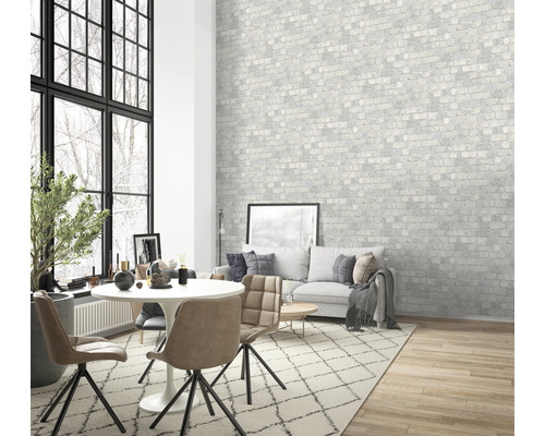 Obývací pokoj s jídelním stolem, židlemi, pohovkou a vzorovanou tapetou s cihlovým motivem