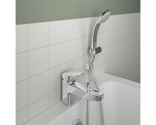 Koupelnová armatura s ruční sprchou a sprchovou hadicí namontovanou na okraji dlaždic