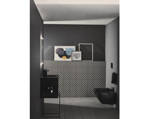 Moderní koupelna s umyvadlem, toaletou a bidetem před vzorovanou stěnou