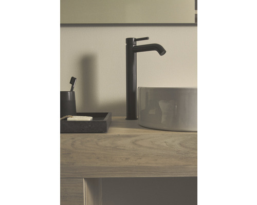 Umyvadlová baterie a umyvadlo na dřevěném stole s mýdlem a zubním kartáčkem