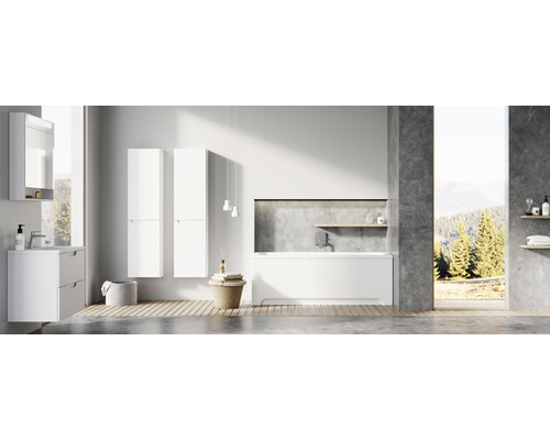 Světlá koupelna s umyvadlovou skříňkou, vysokými skříněmi a vanou.