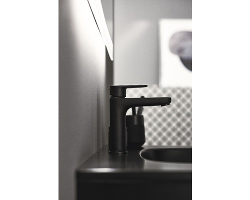 Černá umyvadlová baterie na umyvadle v koupelně.